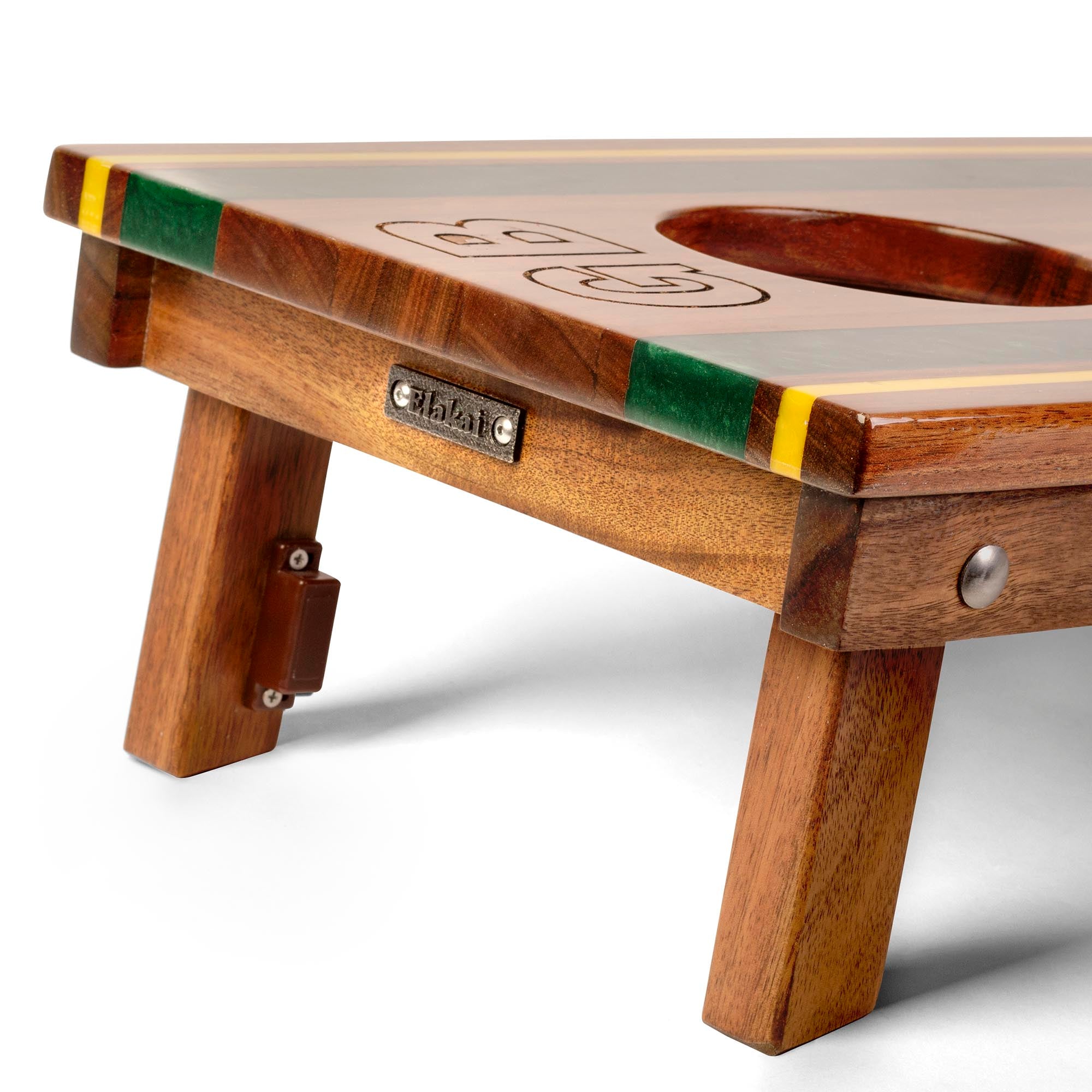 close-up detail of travel board with resin inlay, team engraving, folding legs, and metal Elakai badge
#color_green bay
