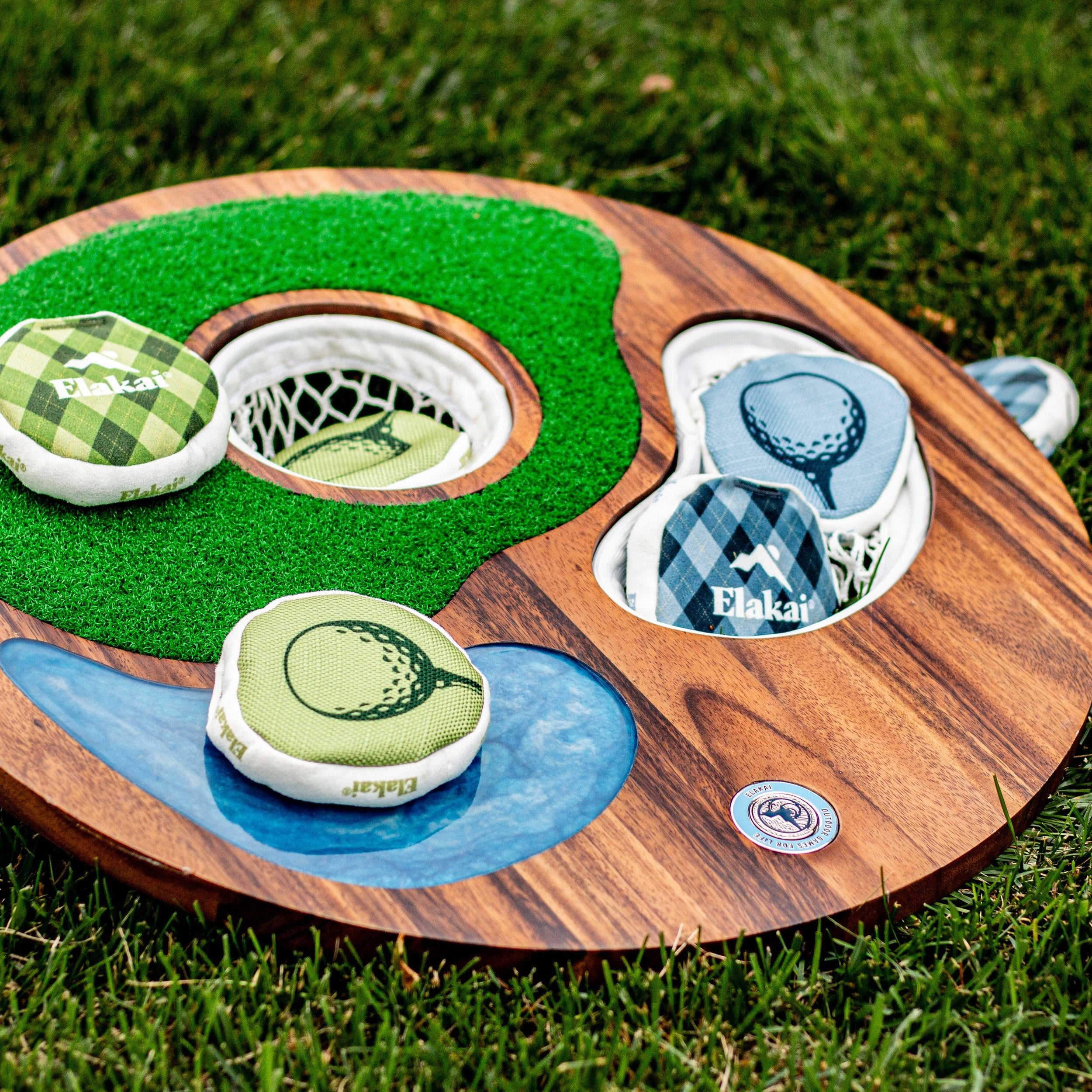 Island Hole golf chipping and cornhole-style game set outdoors on grass with game bags resting in the target areas
