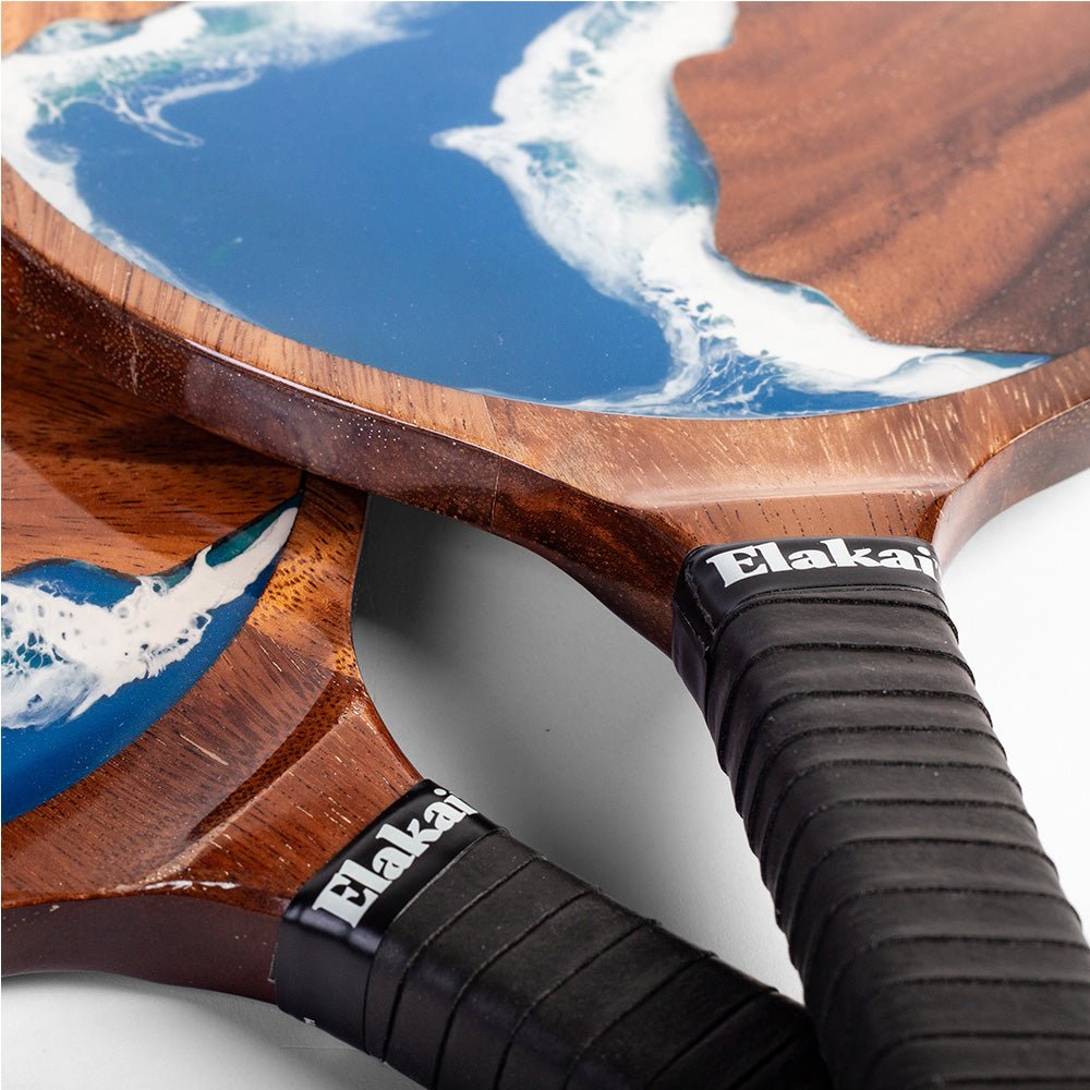 Close-up of Elakai wood and resin paddles with comfortable wrapped handles