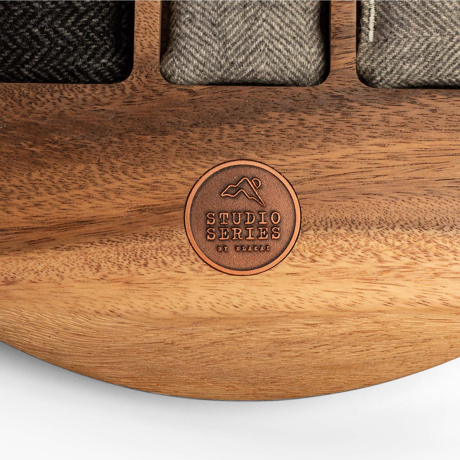 Close-up detail of the branded logo on an acacia wood tic tac toe board showing natural wood grain and craftsmanship