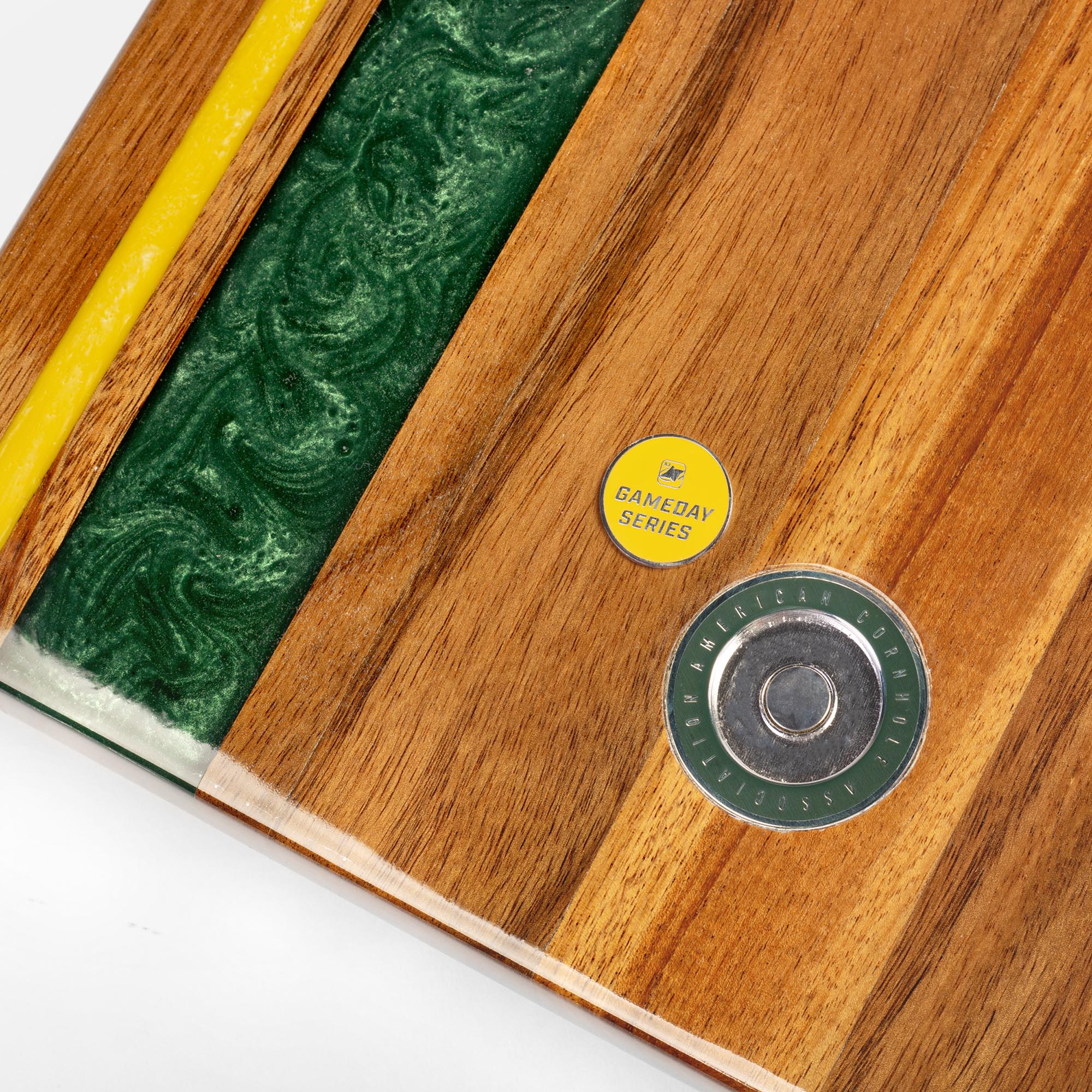 close-up detail of resin inlay and gameday coin insert on travel cornhole board
#color_green bay