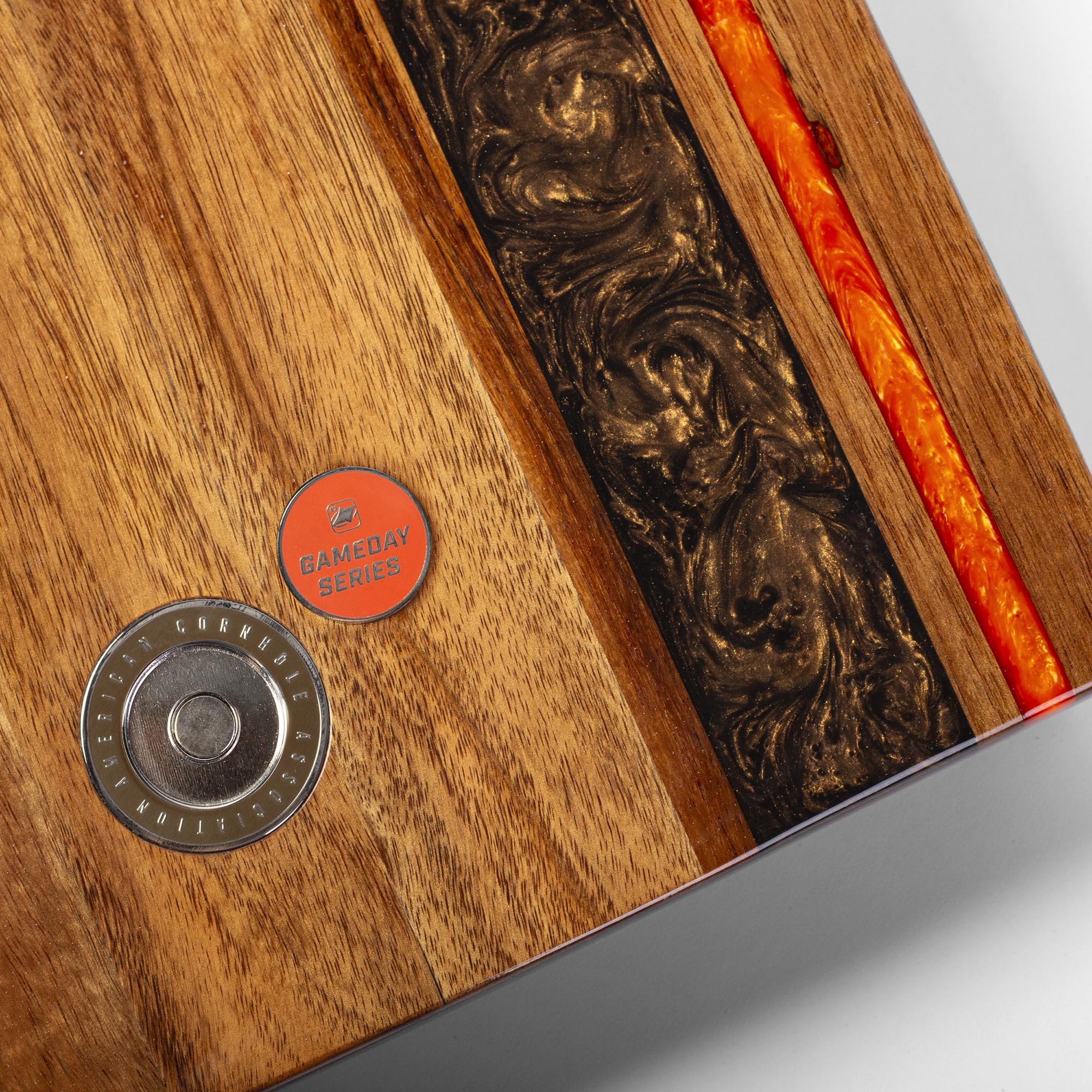 close-up detail of resin inlay and gameday coin insert on travel cornhole board
#color_cleveland