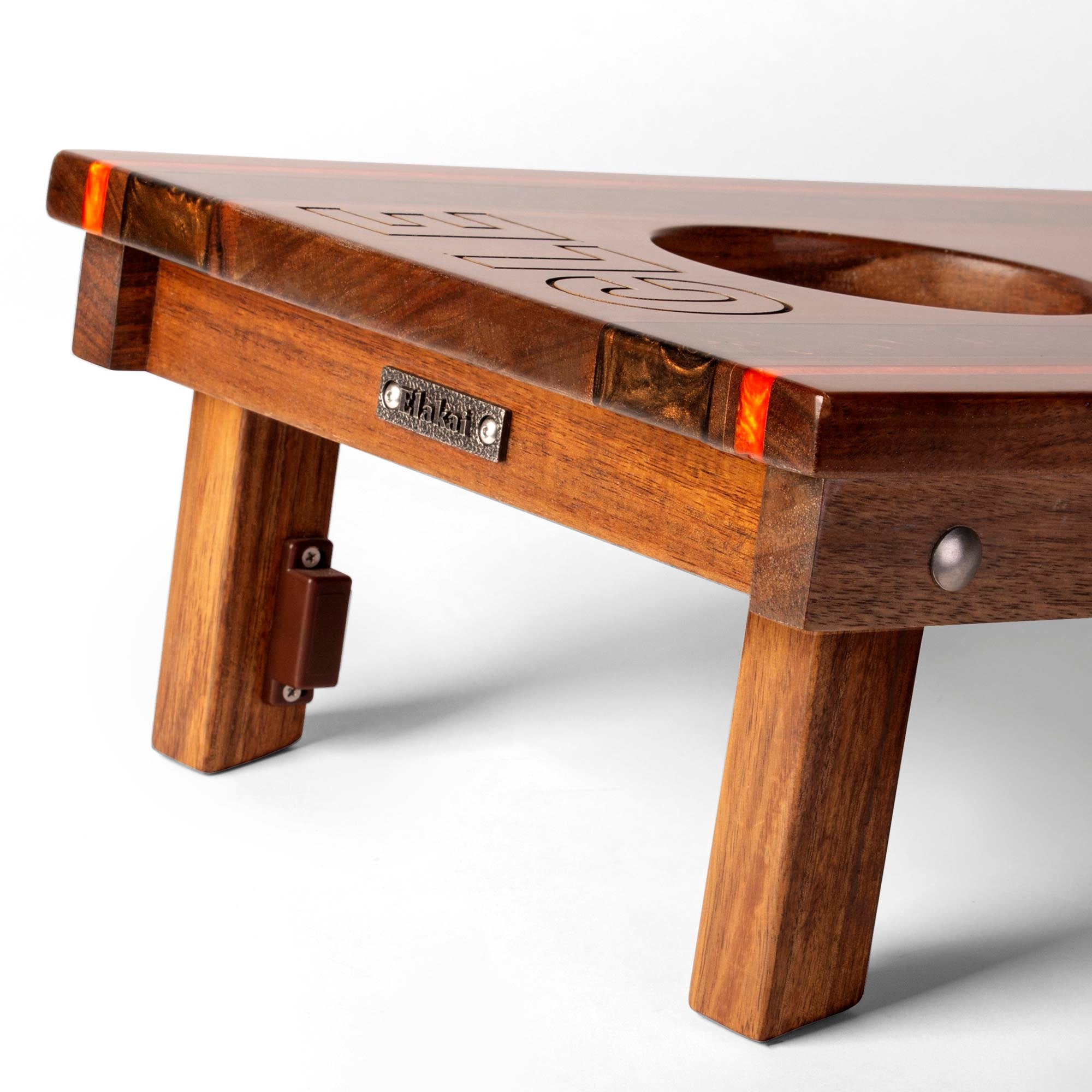 close-up detail of travel board with resin inlay, team engraving, folding legs, and metal Elakai badge 
#color_cleveland