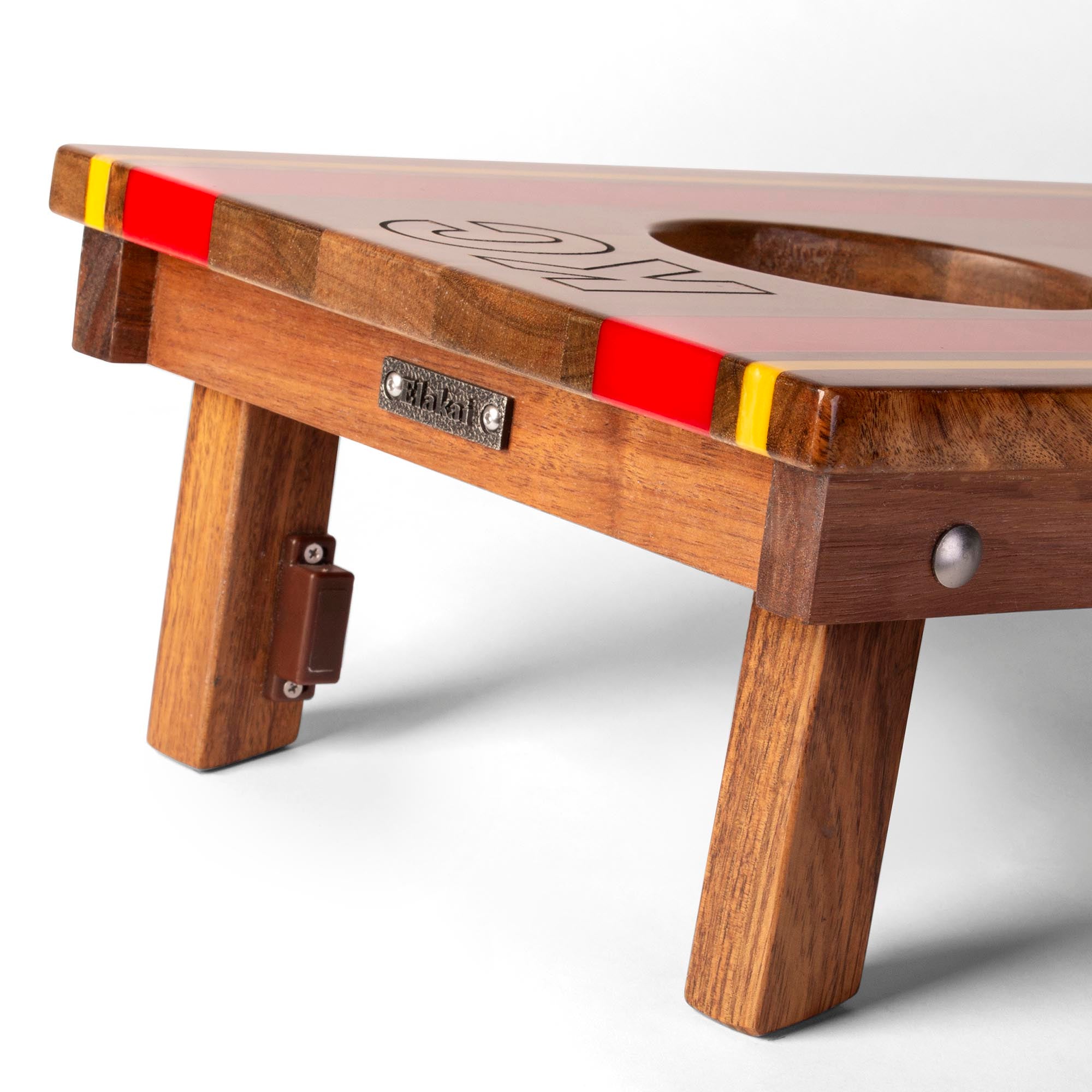 close-up detail of travel board with resin inlay, team engraving, folding legs, and metal Elakai badge 
#color_kansas city