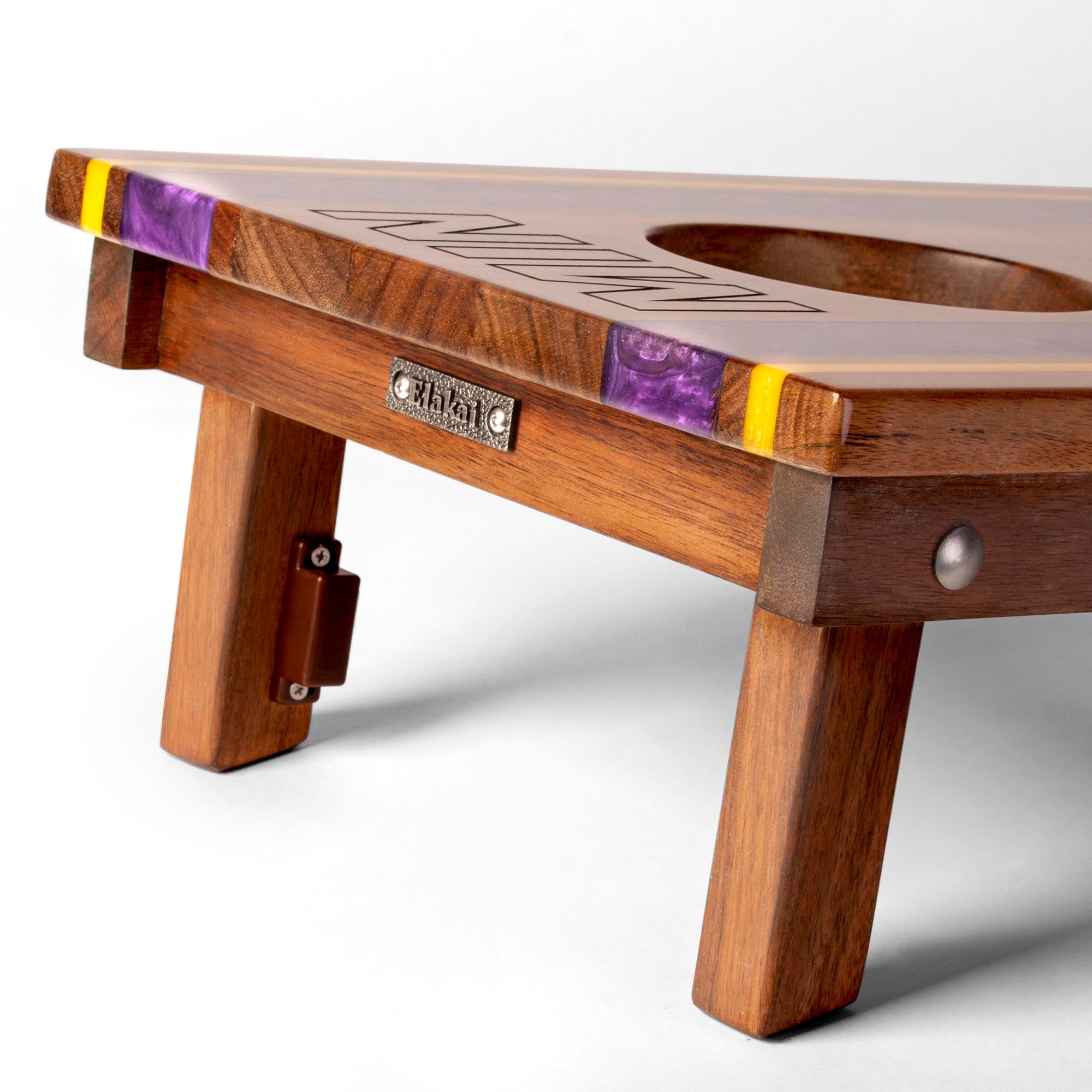 close-up detail of travel board with resin inlay, team engraving, folding legs, and metal Elakai badge 
#color_minnesota
