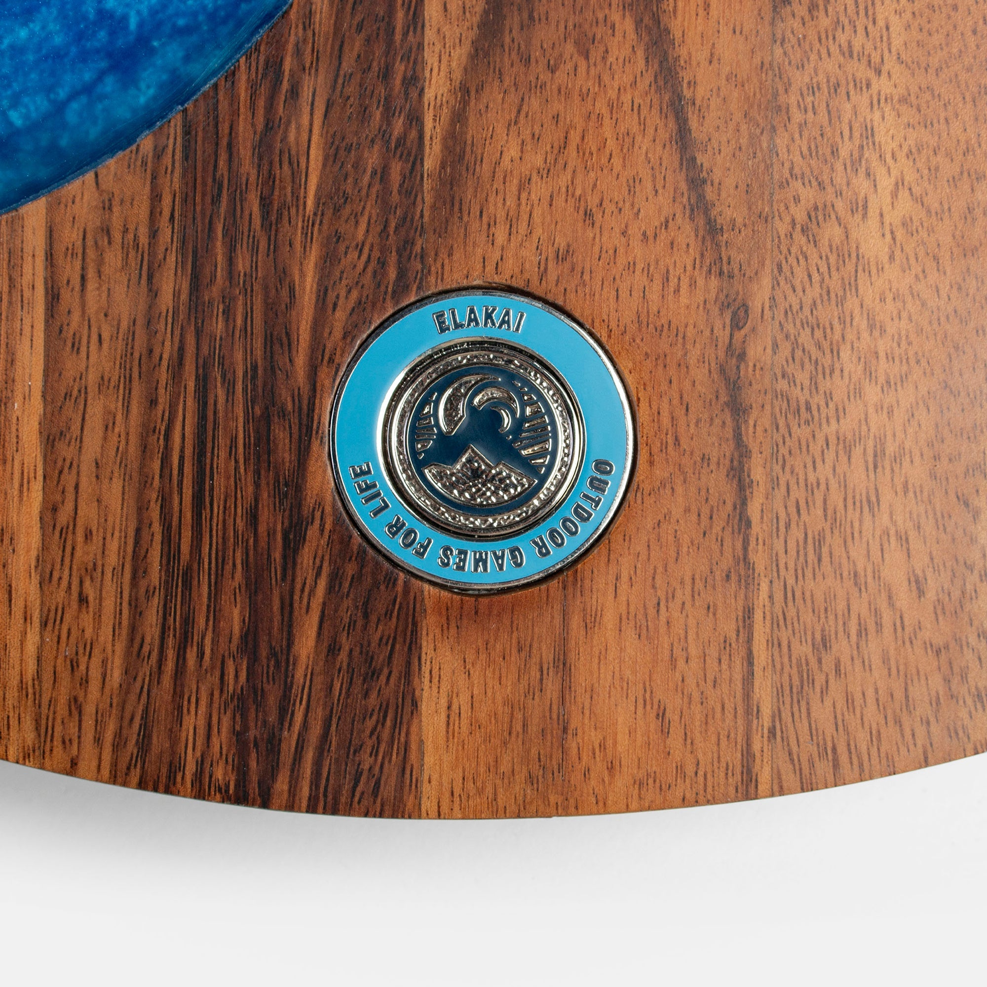 Close-up of a wooden product with a blue and gold logo on a white background