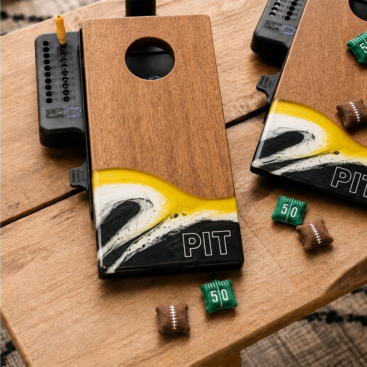 Two wooden cornhole boards featuring a yellow, white, and black wave design at the bottom with 'PIT' lettering.

#color_pittsburgh