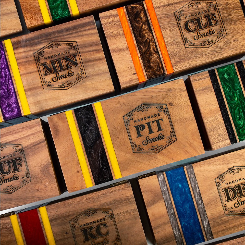 Collection of Elakai handcrafted cedar-lined cigar boxes in multiple resin color designs for cigar collectors and football fans.

#color_buffalo