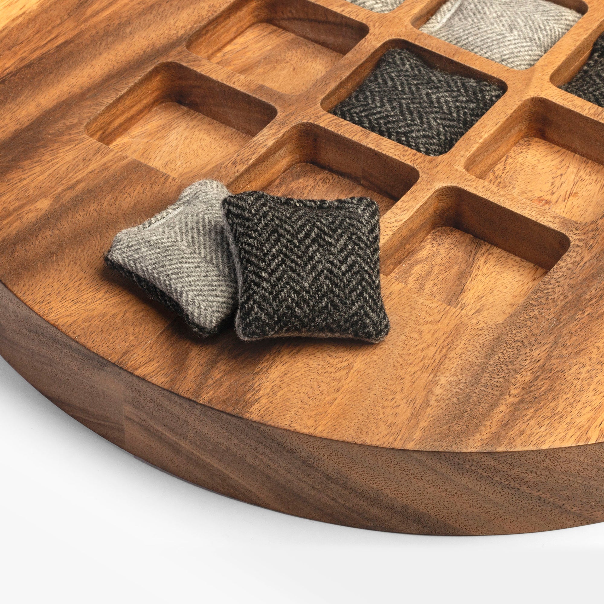 Wooden tray with square fabric samples on a white background