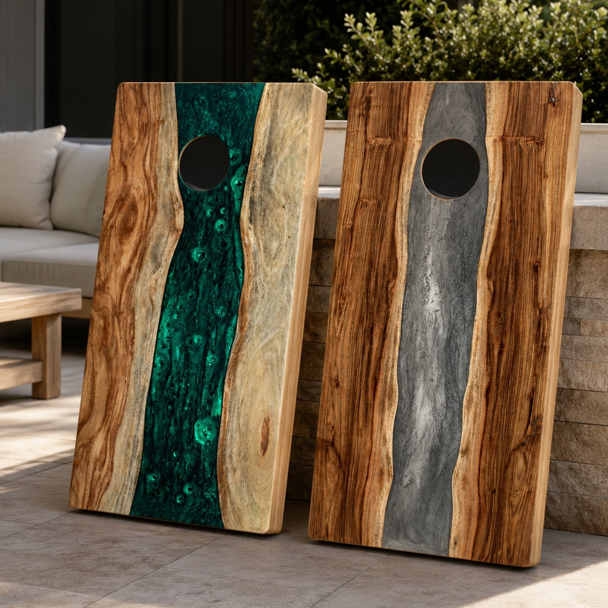 Two rustic cornhole boards leaning outdoors on a patio. Each board has a circular scoring hole and is made from natural wood with a central inlay: one board has a bright green malachite-like vein, and the other has a gray stone-like vein. #color_gray stone