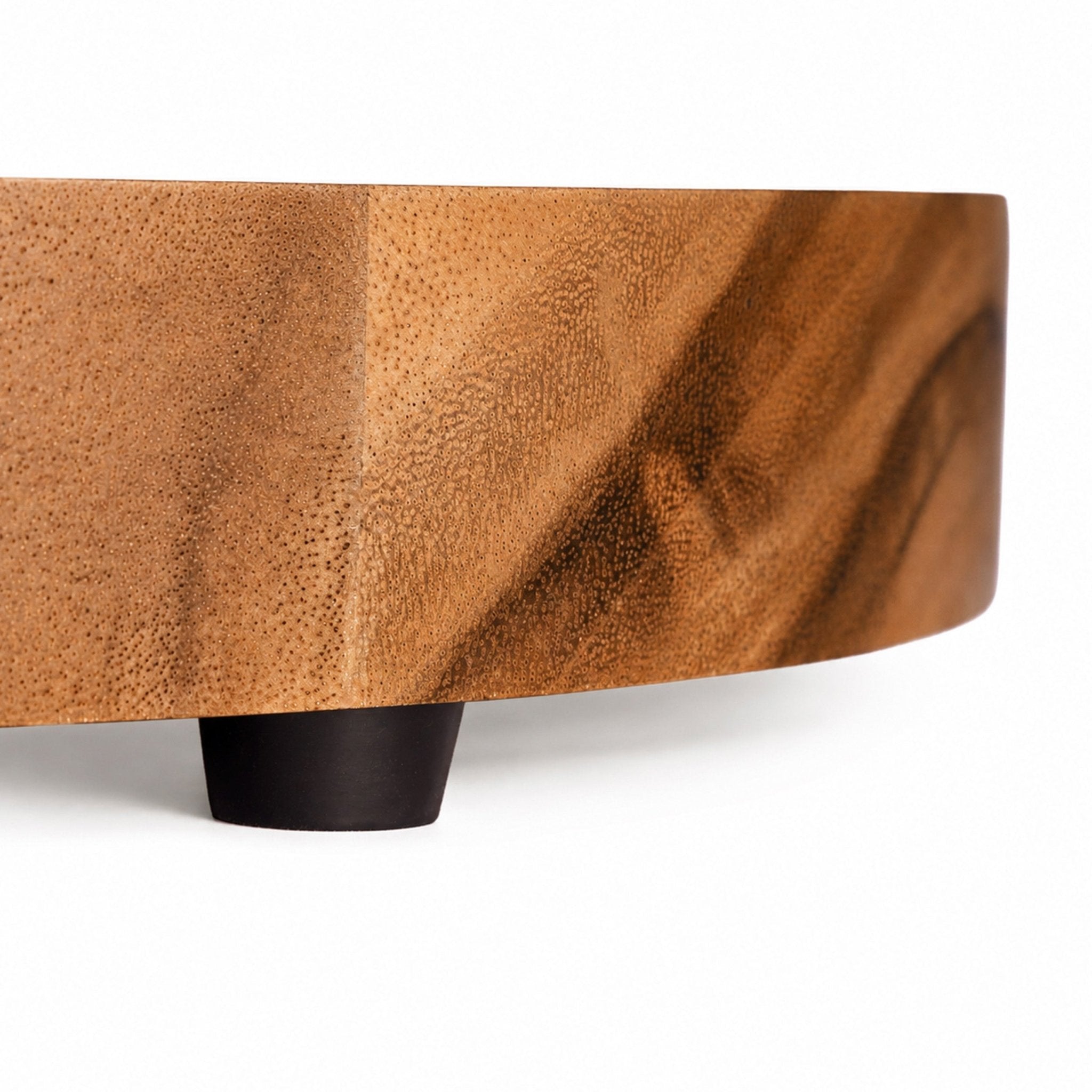 Profile view of the live edge acacia tabletop showing the hand-finished surface and low-profile black foot