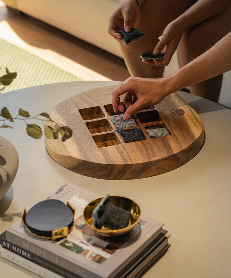 Close-up of the Studio Series Tic Tac Toe game as two people play on a modern coffee table. 